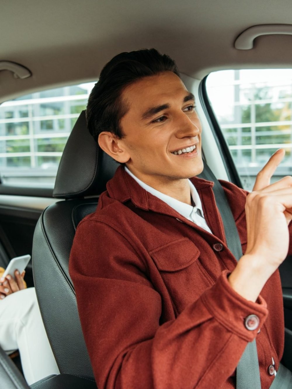 smiling-taxi-driver-and-passenger-with-smartphone-in-car-e1635074849312.jpg