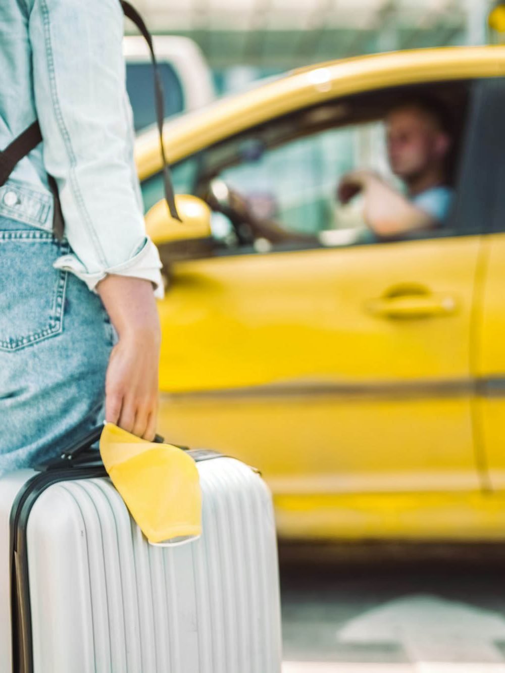 woman-waiting-for-taxi-with-face-mask-and-travel-case.jpg